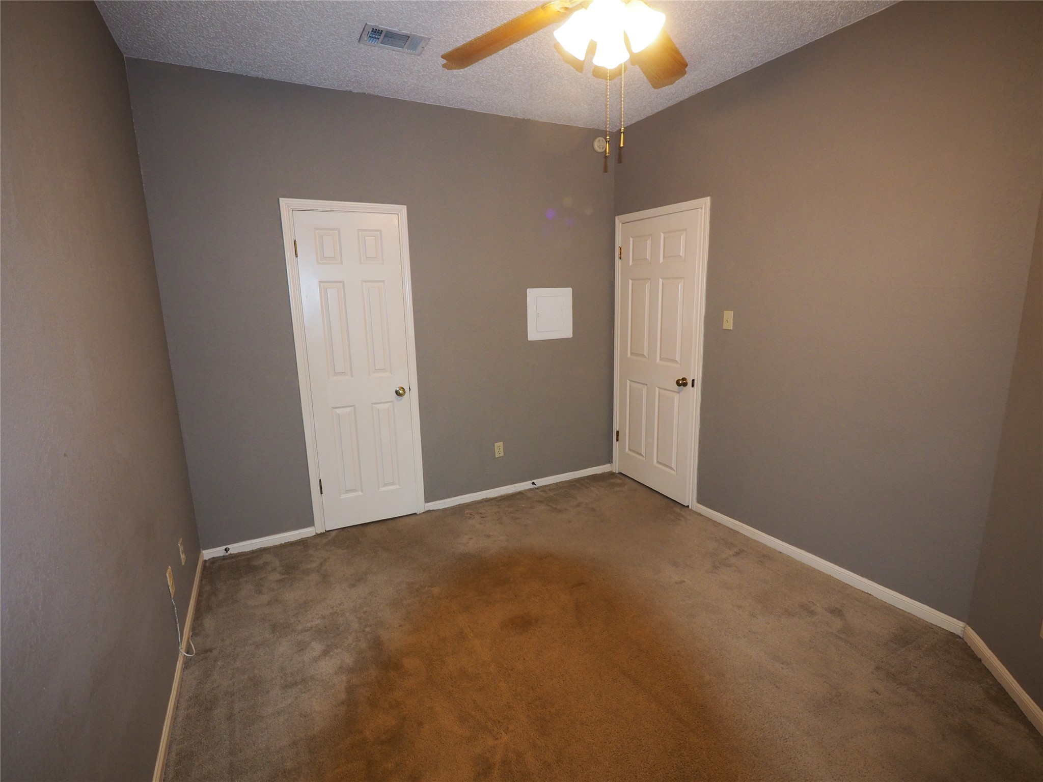 2508 Enfield Road, Unit 10 Austin, TX 78703 - Photo 15 of 17 Interior room featuring neutral wall paint, two paneled doors, ceiling fan with integrated lighting, and carpeted flooring
