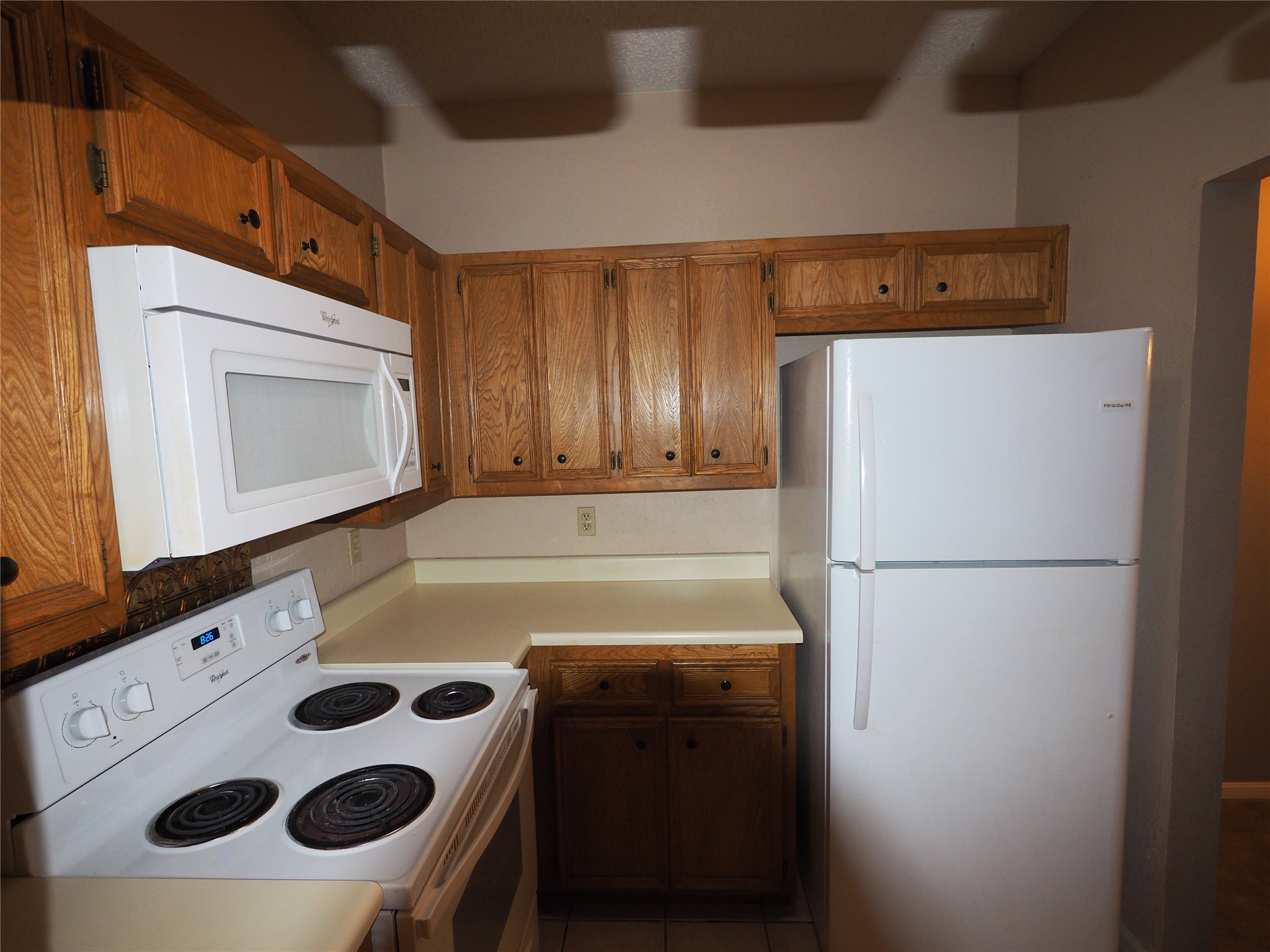 2508 Enfield Road, Unit 10 Austin, TX 78703 - Photo 6 of 17 Kitchen with wood-finish cabinetry, white appliances including a refrigerator, range, and built-in microwave, and light-toned countertops