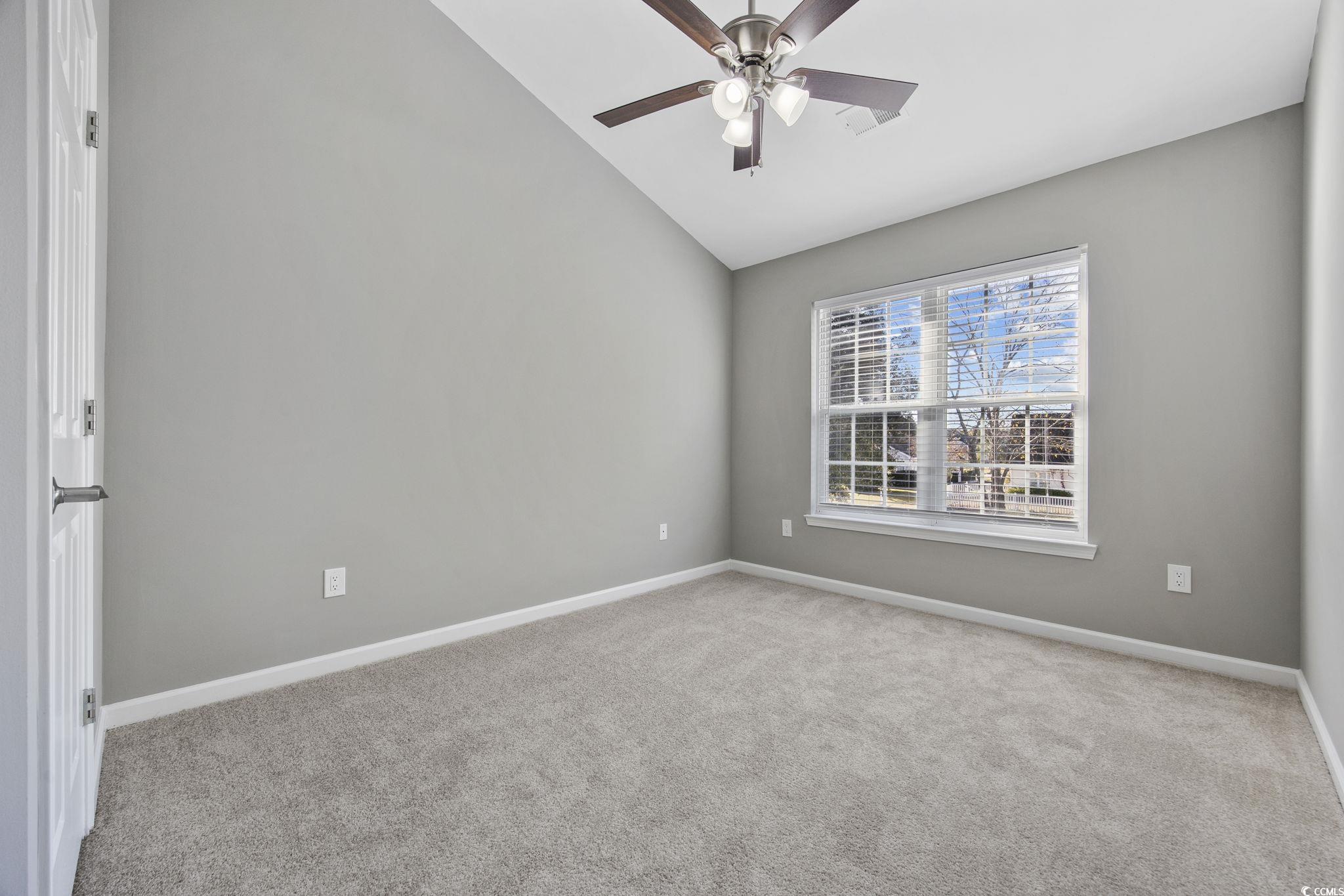 629 Slash Pine Court Myrtle Beach, SC 29579 - Photo 17 of 40 Spare room featuring light colored carpet, vaulted ceiling, and ceiling fan