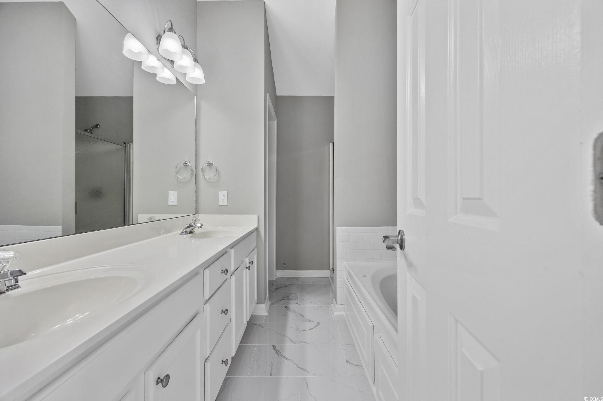 629 Slash Pine Court Myrtle Beach, SC 29579 - Photo 26 of 40 Full bath with double vanity, a garden tub, light marble finish floors, and a shower