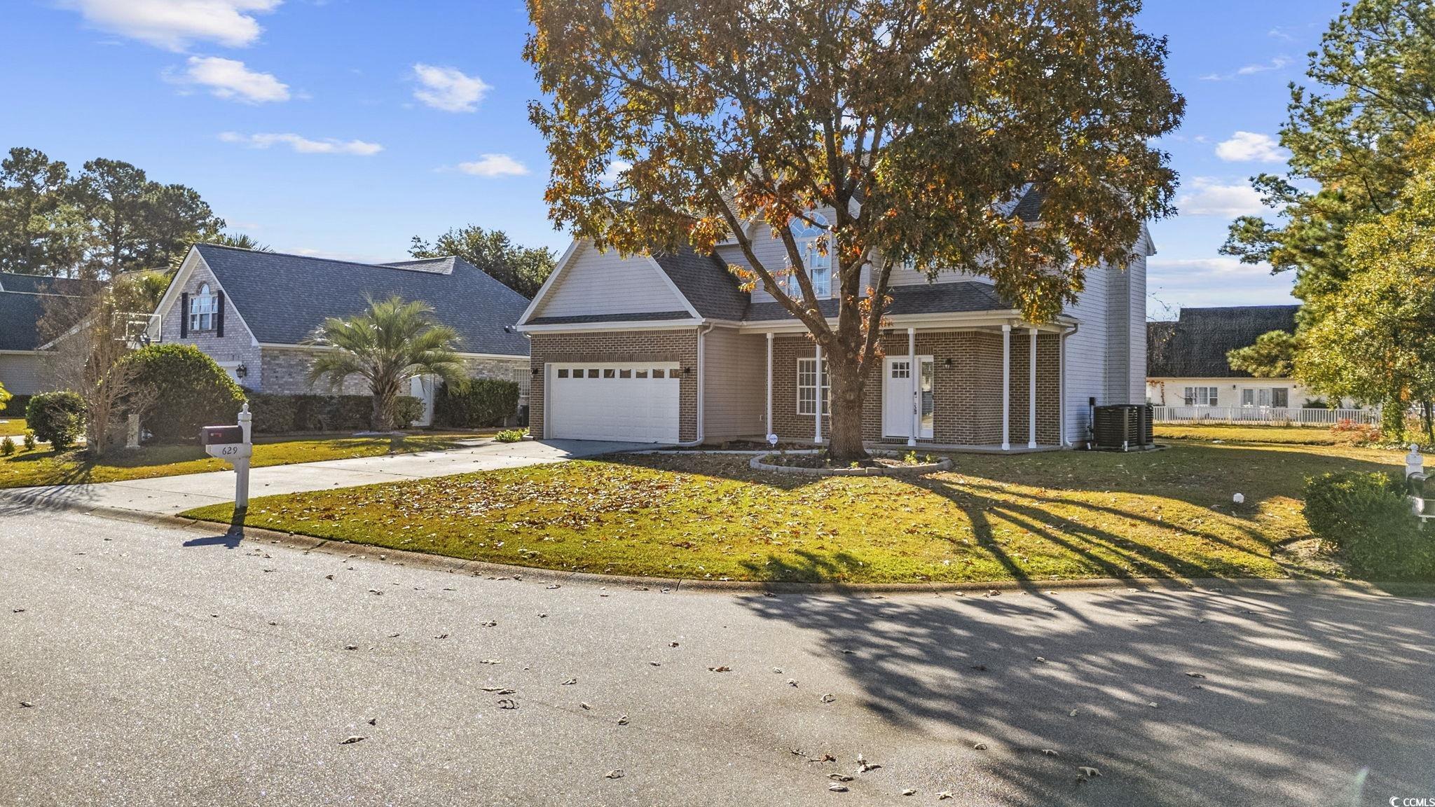 629 Slash Pine Court Myrtle Beach, SC 29579 - Photo 33 of 40 Traditional-style house with concrete driveway, a front yard, covered porch, and a garage