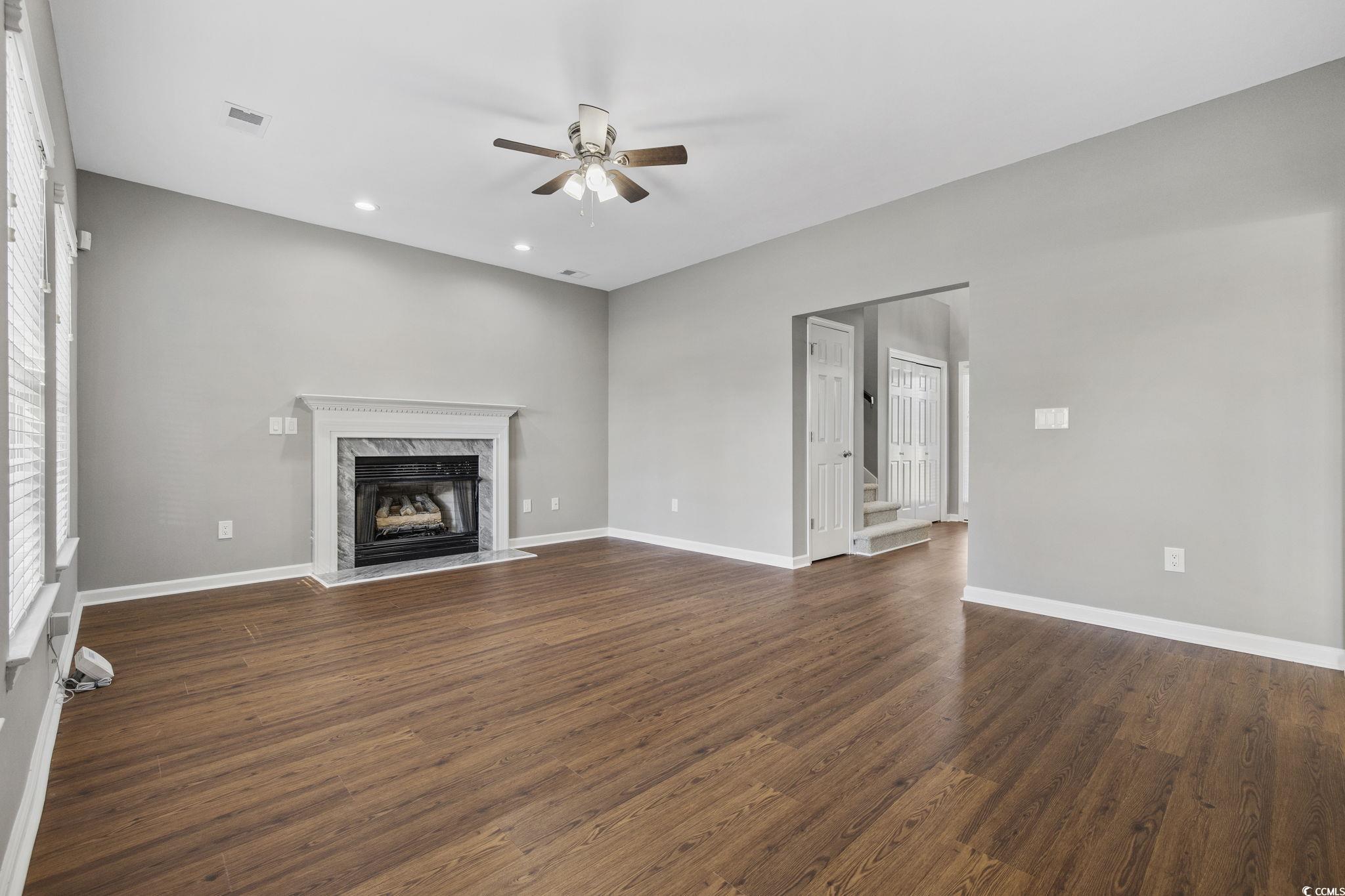629 Slash Pine Court Myrtle Beach, SC 29579 - Photo 4 of 40 Unfurnished living room featuring dark wood-type flooring, a fireplace, recessed lighting, and a ceiling fan