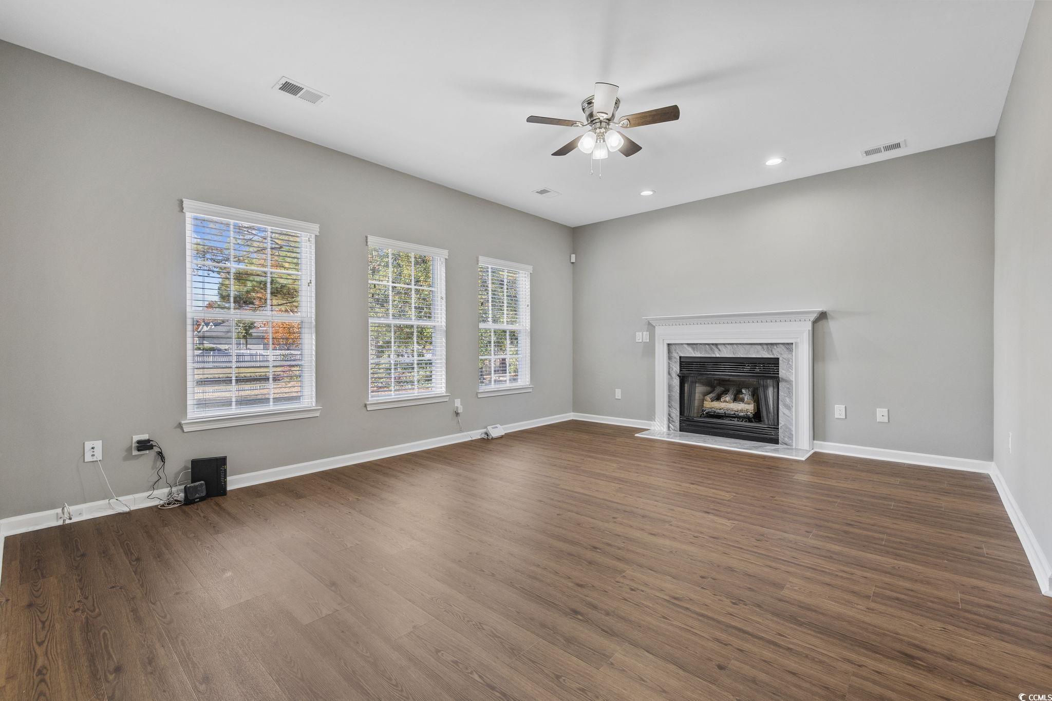 629 Slash Pine Court Myrtle Beach, SC 29579 - Photo 5 of 40 Unfurnished living room with a high end fireplace, dark wood-style flooring, recessed lighting, and a ceiling fan