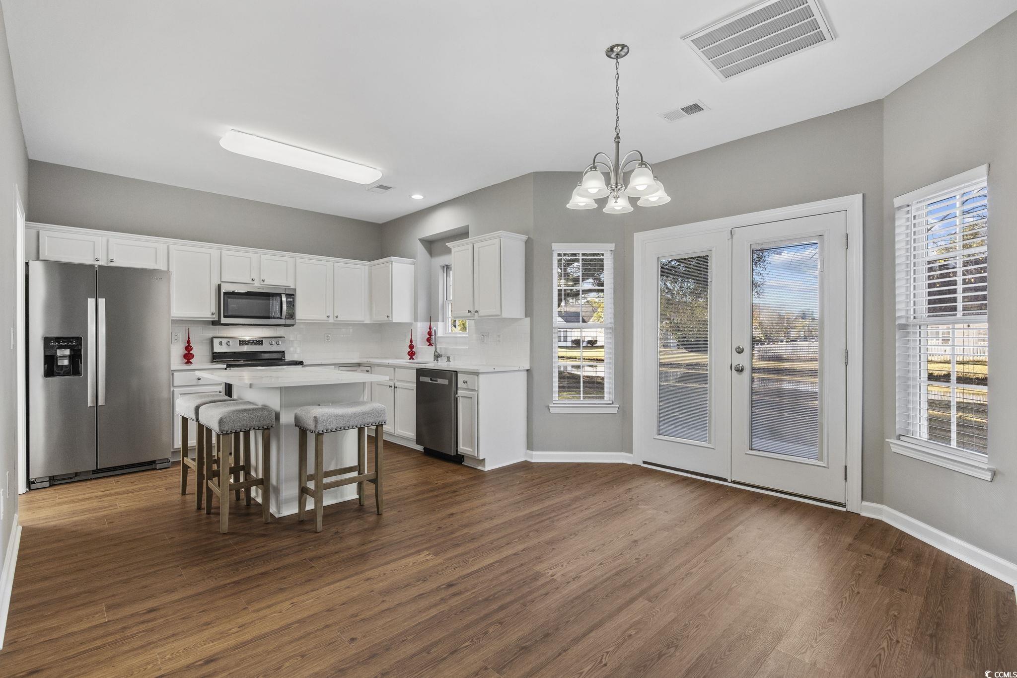 629 Slash Pine Court Myrtle Beach, SC 29579 - Photo 8 of 40 Kitchen featuring appliances with stainless steel finishes, a chandelier, white cabinetry, hanging light fixtures, and dark wood finished floors