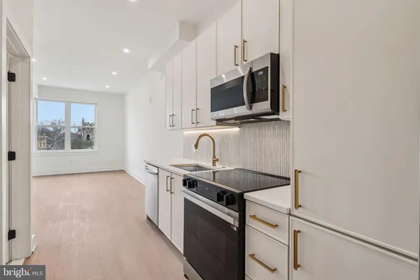 a kitchen with stainless steel appliances granite countertop a sink and a microwave