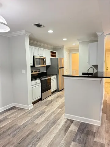 a view of kitchen with granite countertop stainless steel appliances and sink