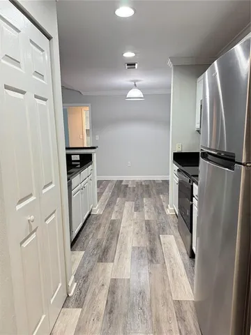 a kitchen with white cabinets and stainless steel appliances
