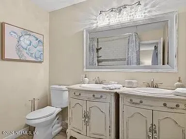 a bathroom with a toilet sink and mirror