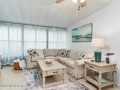 a living room with furniture a couch and a potted plant