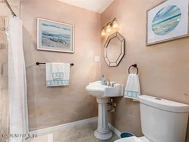 a bathroom with a toilet a sink and a mirror