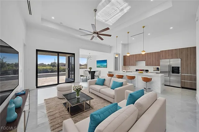 a living room with furniture kitchen view and a large window