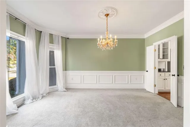 a spacious bedroom with a bed and a chandelier