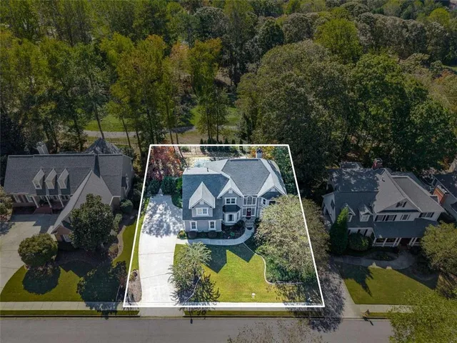 an aerial view of residential houses with outdoor space and trees