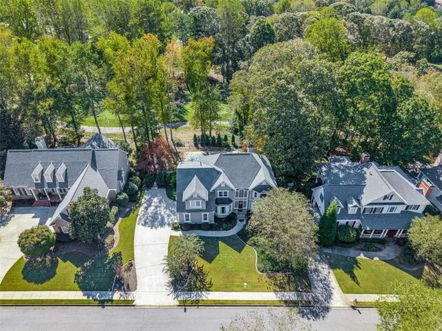 a front view of a house with a yard and trees