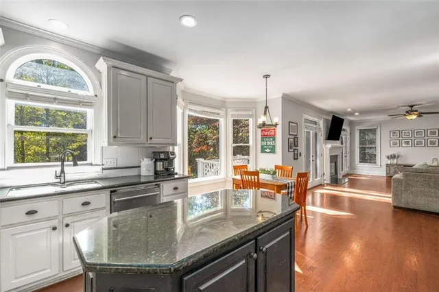 a kitchen with stainless steel appliances granite countertop a refrigerator a stove and a sink with wooden floor