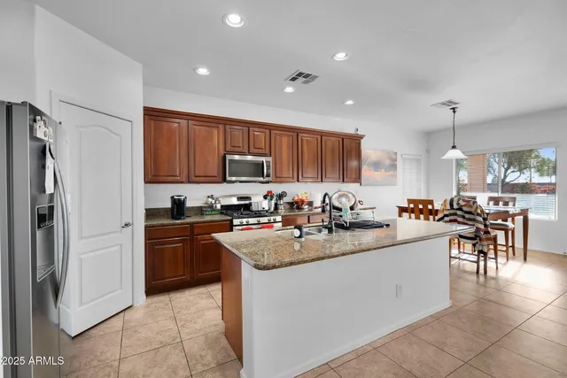 a living room with furniture kitchen view and a chandelier