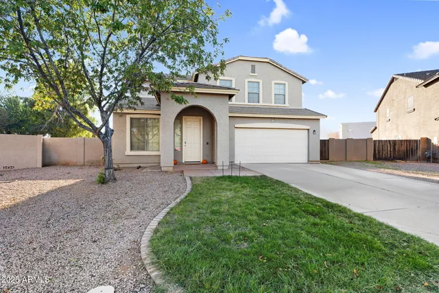 a front view of a house with a yard and a garage