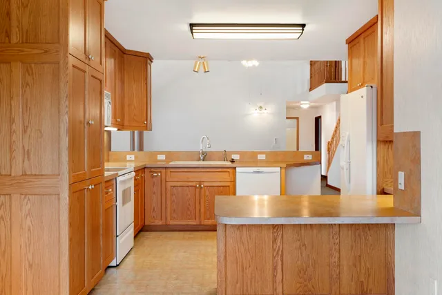 a kitchen with stainless steel appliances granite countertop a sink and a refrigerator