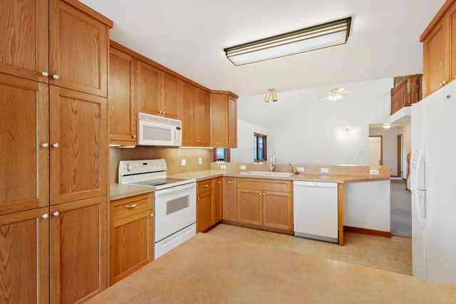 a kitchen with cabinets and white stainless steel appliances