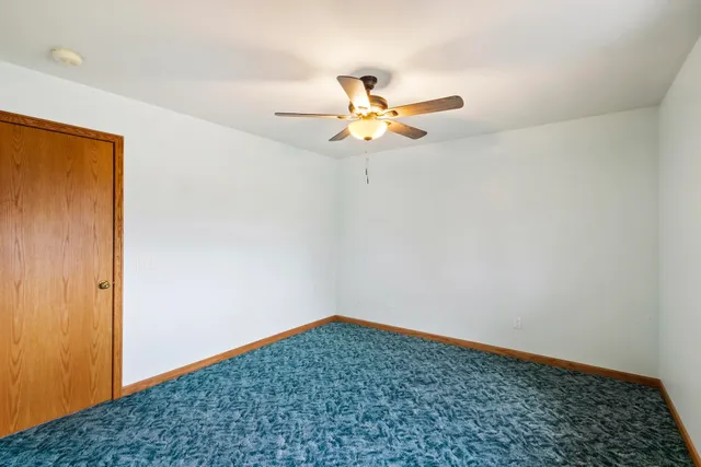 a view of a room with a ceiling fan and a window