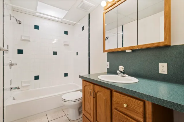 a bathroom with a sink a washer and dryer next to a window