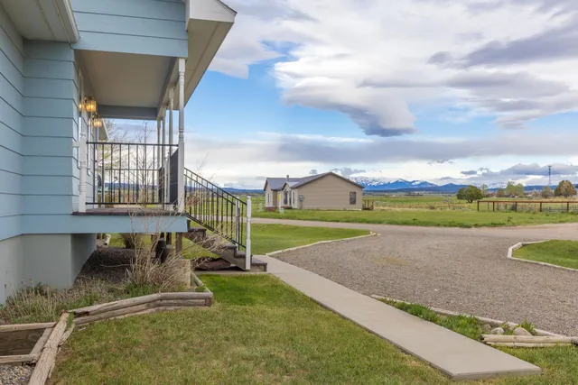 a view of a house with a big yard and large trees
