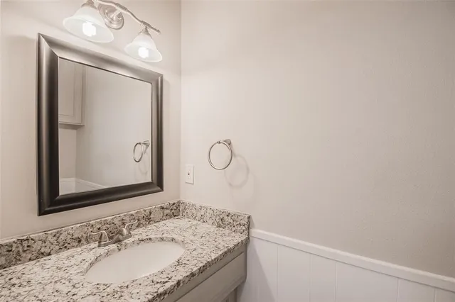 a bathroom with a granite countertop sink mirror and vanity
