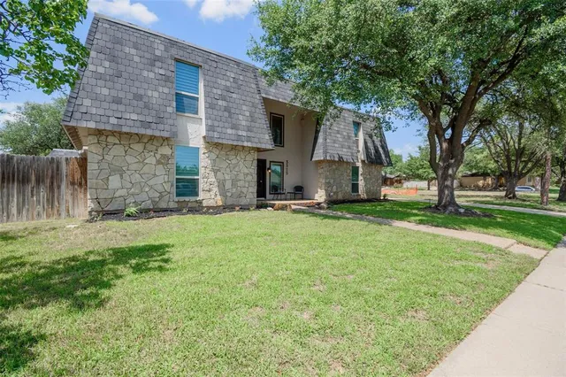 a view of a house with backyard and a tree