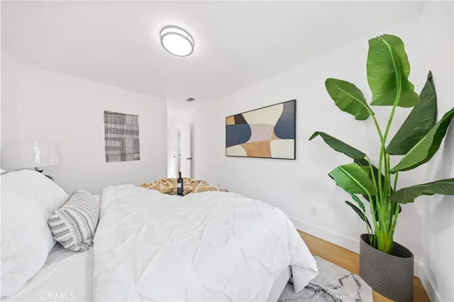 a bedroom with a large bed and a potted plant