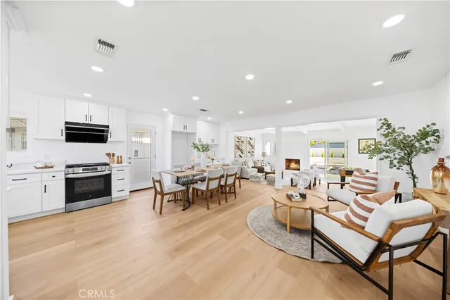 a living room with fireplace furniture and kitchen view