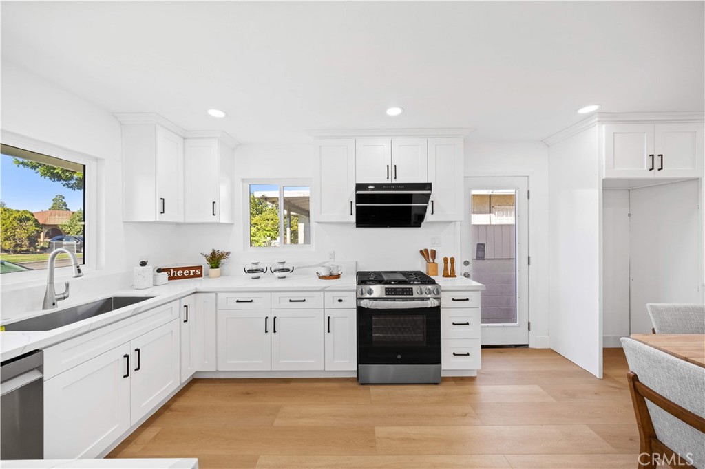 2274 Cogswell Road El Monte, CA 91732 - Photo 4 of 26 a kitchen with stainless steel appliances granite countertop a stove top oven a sink a refrigerator and white cabinets with wooden floor