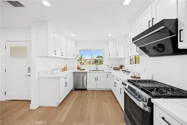 a kitchen with granite countertop stainless steel appliances and white cabinets