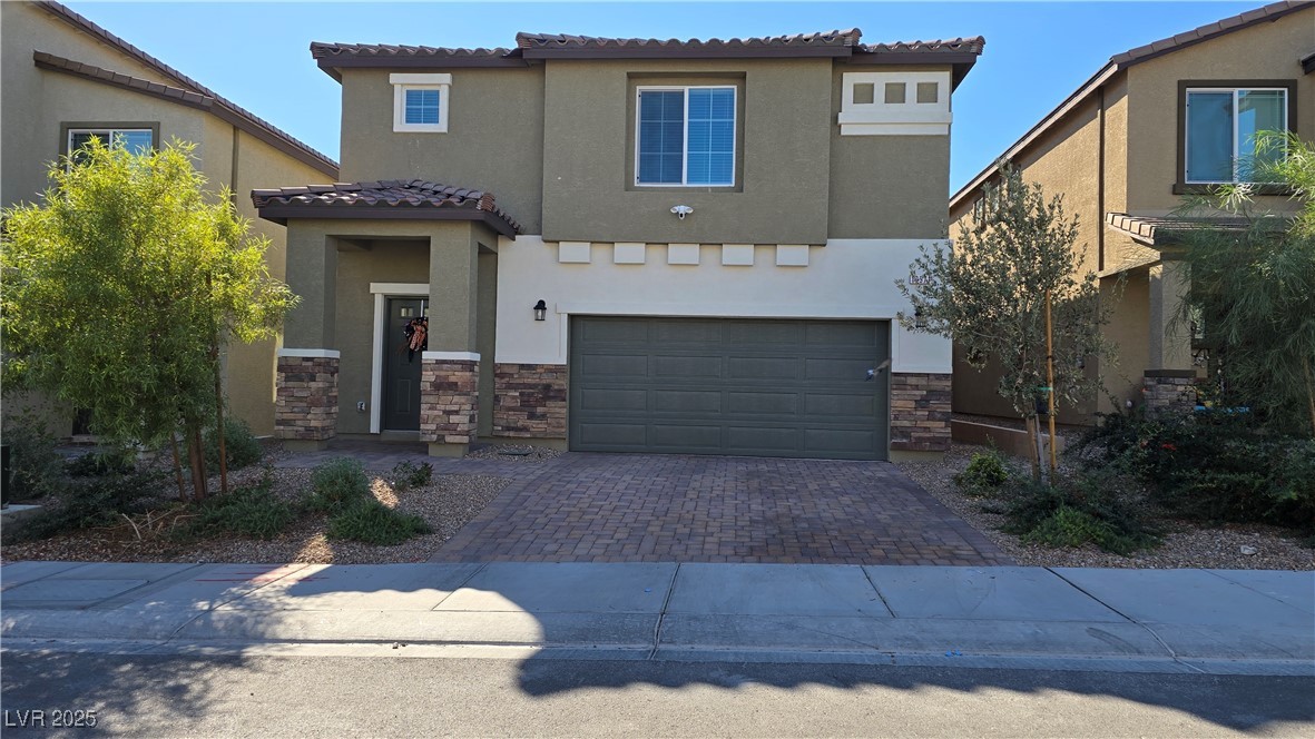 10971 Meridian Fields Avenue Las Vegas, NV 89166 - Photo 1 of 66 Mediterranean / spanish house with decorative driveway, a tile roof, stone siding, and stucco siding