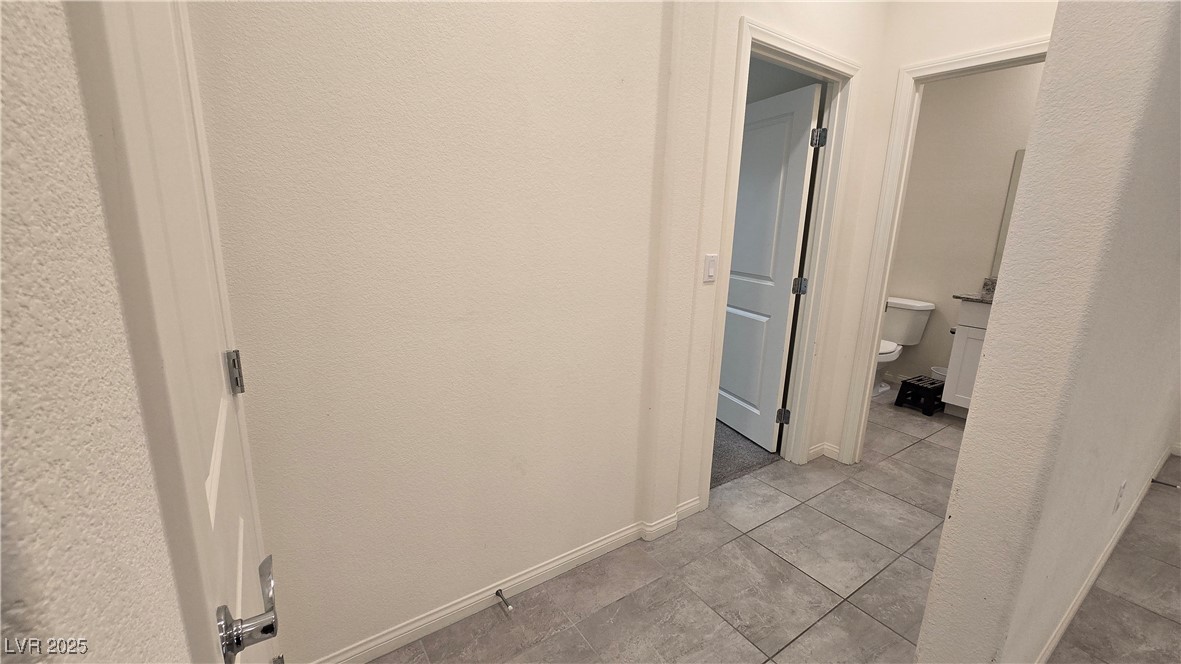 10971 Meridian Fields Avenue Las Vegas, NV 89166 - Photo 13 of 66 Corridor with a textured wall and light tile patterned floors