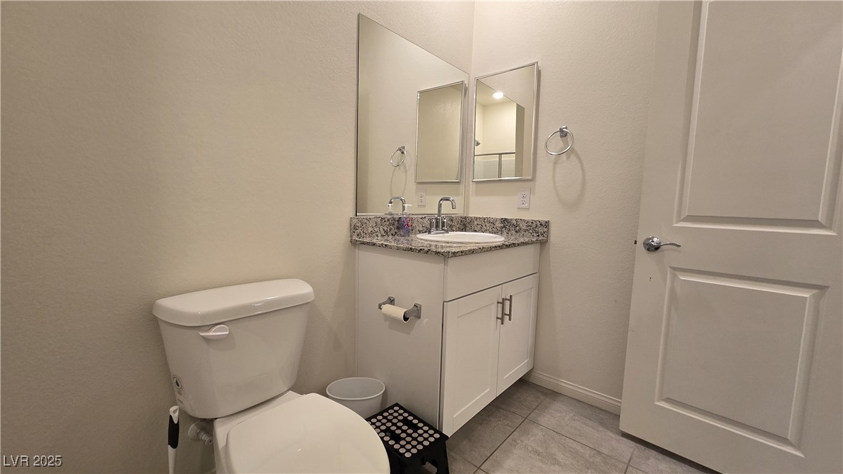 10971 Meridian Fields Avenue Las Vegas, NV 89166 - Photo 17 of 66 Bathroom featuring light tile patterned flooring, vanity, and a textured wall
