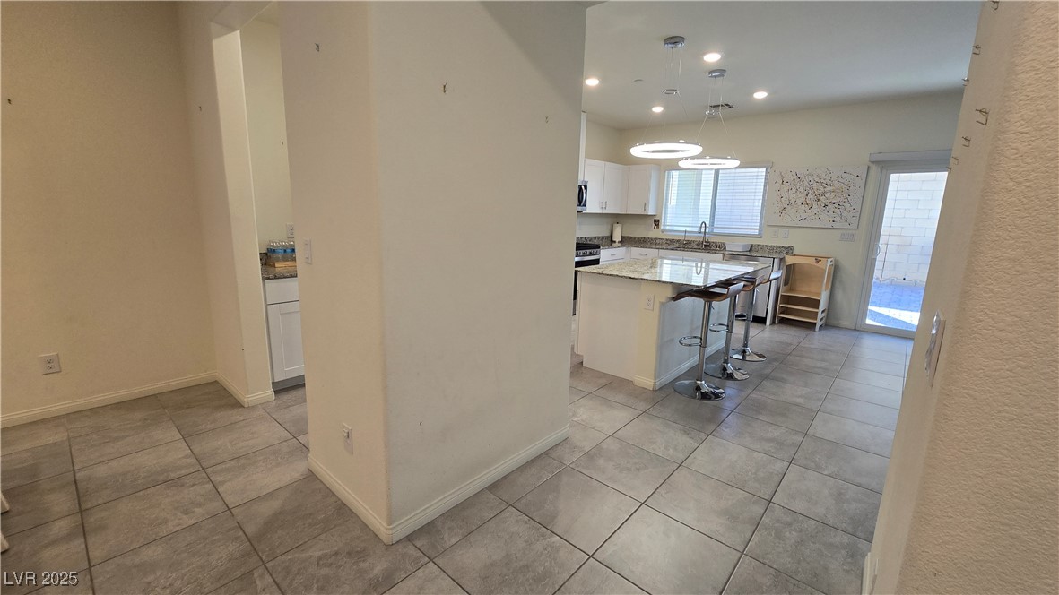 10971 Meridian Fields Avenue Las Vegas, NV 89166 - Photo 18 of 66 Kitchen with white cabinetry, pendant lighting, light tile patterned floors, a center island, and recessed lighting