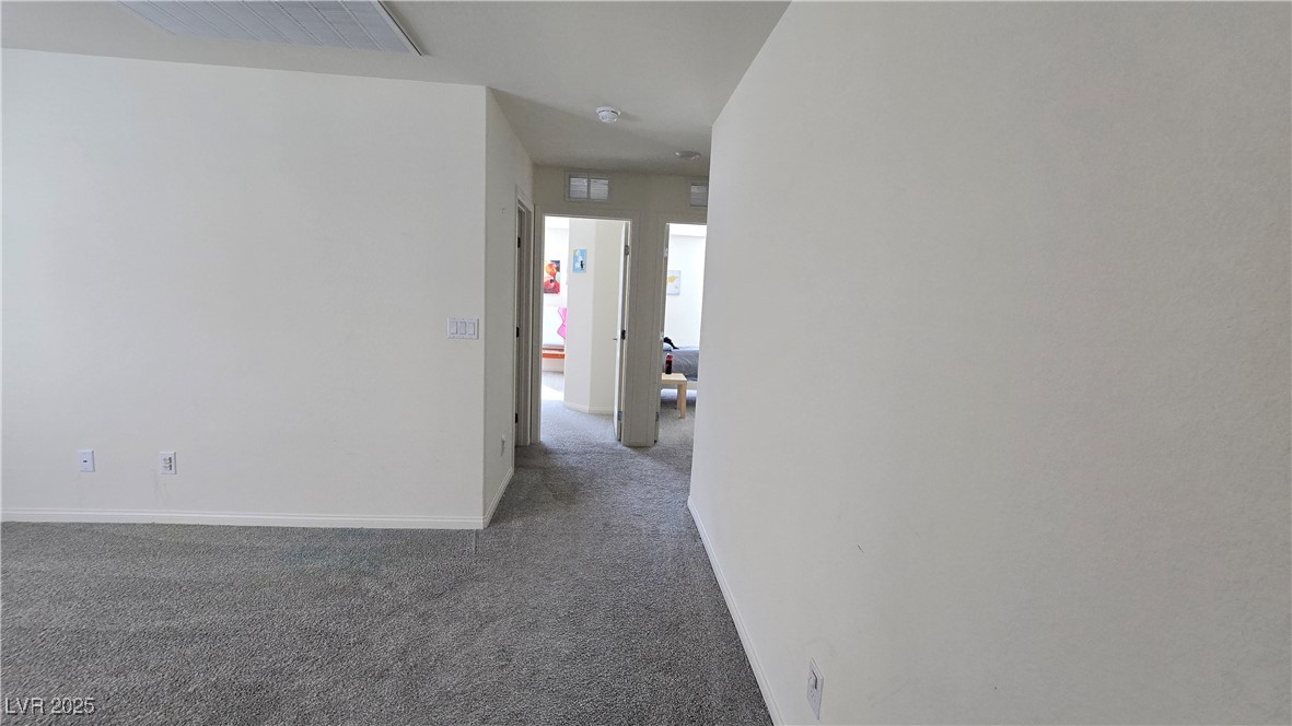 10971 Meridian Fields Avenue Las Vegas, NV 89166 - Photo 43 of 66 Hallway with dark colored carpet and baseboards