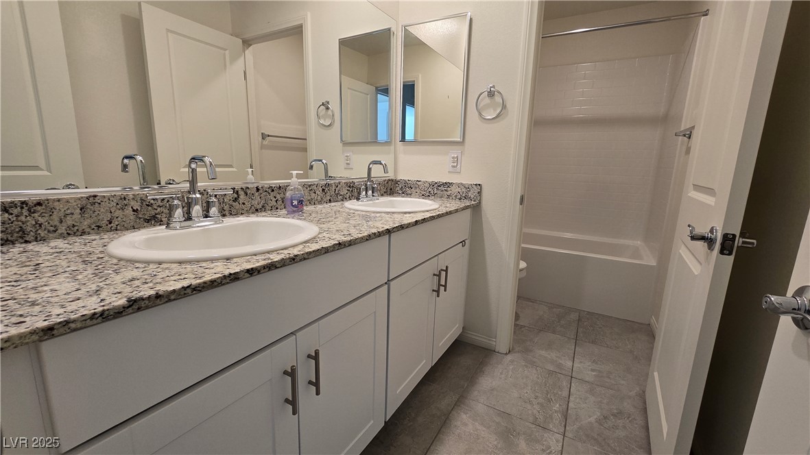 10971 Meridian Fields Avenue Las Vegas, NV 89166 - Photo 44 of 66 Bathroom featuring double vanity, shower / bath combination, and light tile patterned floors