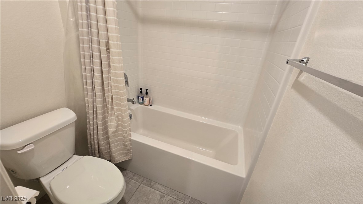 10971 Meridian Fields Avenue Las Vegas, NV 89166 - Photo 46 of 66 Full bath featuring a textured wall, shower / bath combination with curtain, and tile patterned flooring