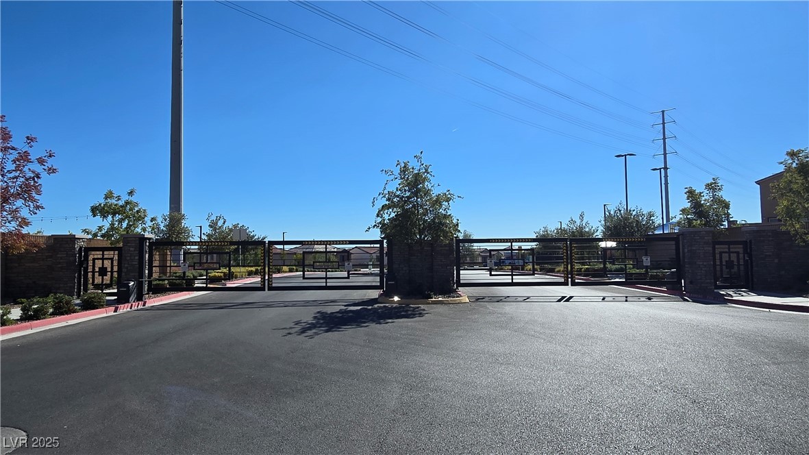 10971 Meridian Fields Avenue Las Vegas, NV 89166 - Photo 59 of 66 View of asphalt road featuring a gate, a gated entry, and curbs