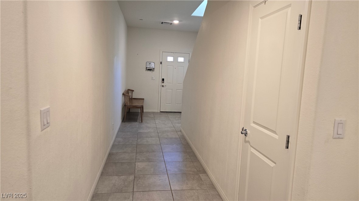 10971 Meridian Fields Avenue Las Vegas, NV 89166 - Photo 6 of 66 Hallway featuring light tile patterned floors and a skylight