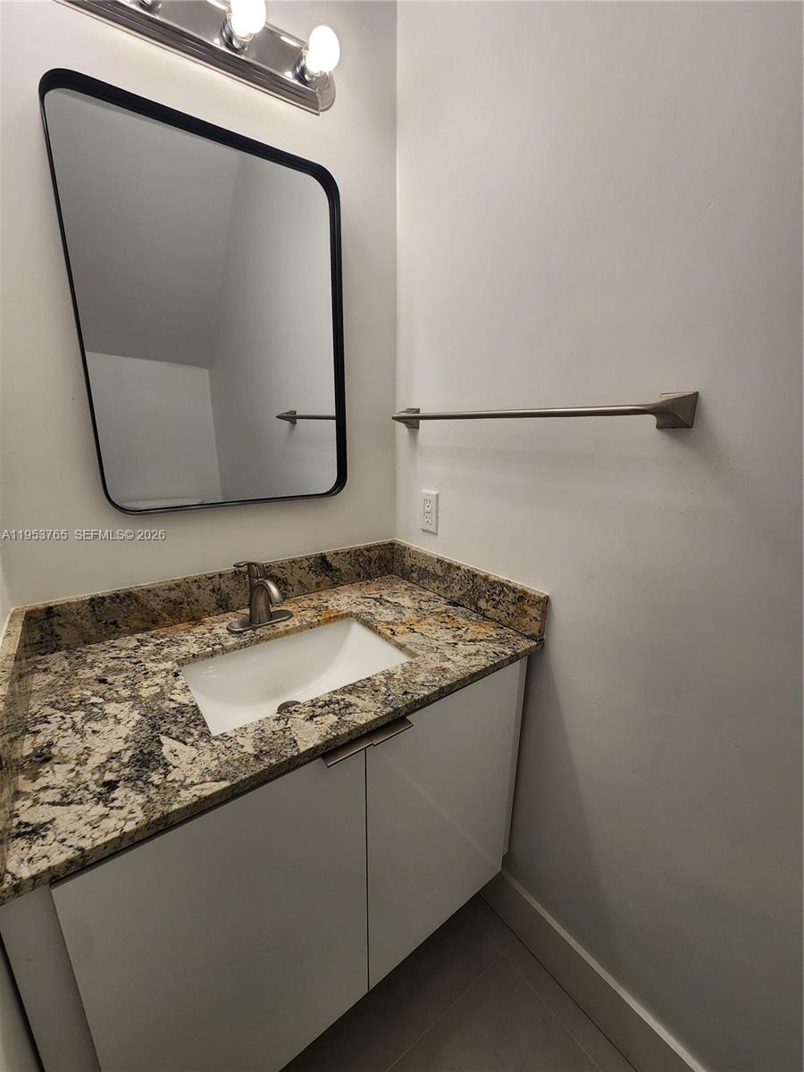 8025 Northwest 8th Street, Unit 10 Miami, FL 33126 - Photo 12 of 26 a bathroom with a granite countertop sink and mirror