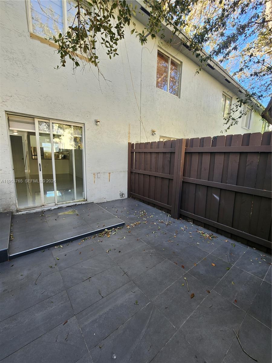 8025 Northwest 8th Street, Unit 10 Miami, FL 33126 - Photo 14 of 26 a view of a house with a wooden fence and a bench