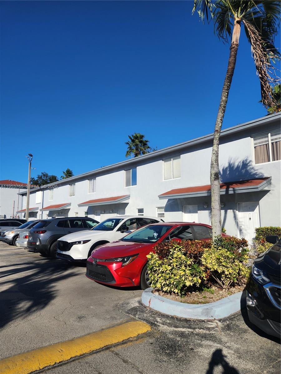 8025 Northwest 8th Street, Unit 10 Miami, FL 33126 - Photo 4 of 26 a view of a patio with couches table and chairs under an umbrella