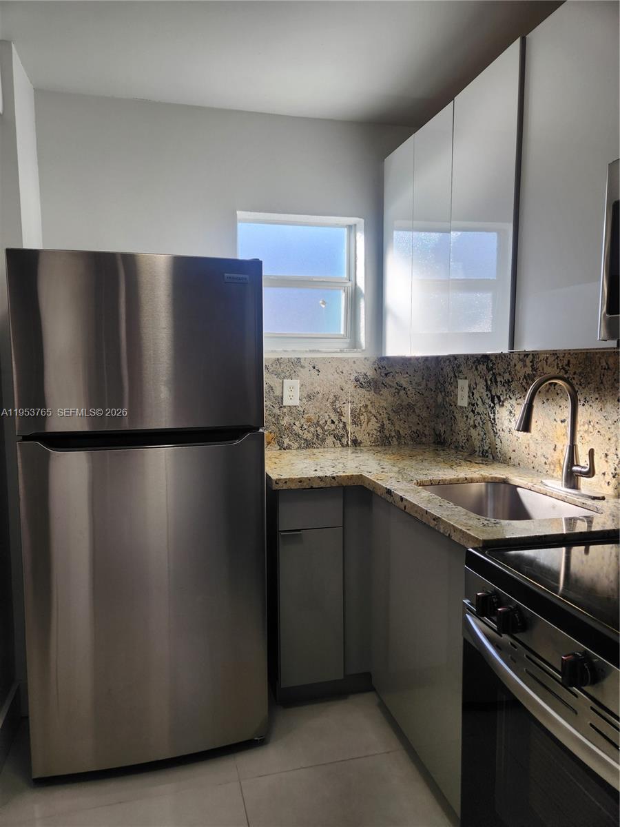 8025 Northwest 8th Street, Unit 10 Miami, FL 33126 - Photo 7 of 26 a kitchen with stainless steel appliances granite countertop a sink stove and refrigerator