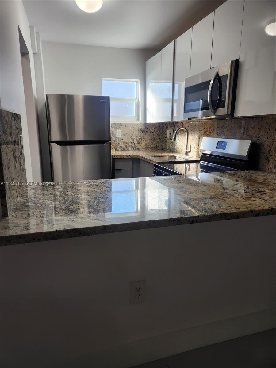 8025 Northwest 8th Street, Unit 10 Miami, FL 33126 - Photo 8 of 26 a kitchen with stainless steel appliances granite countertop a sink and a refrigerator
