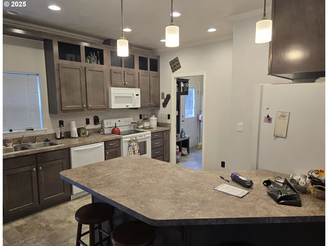 a kitchen with granite countertop a sink appliances and cabinets