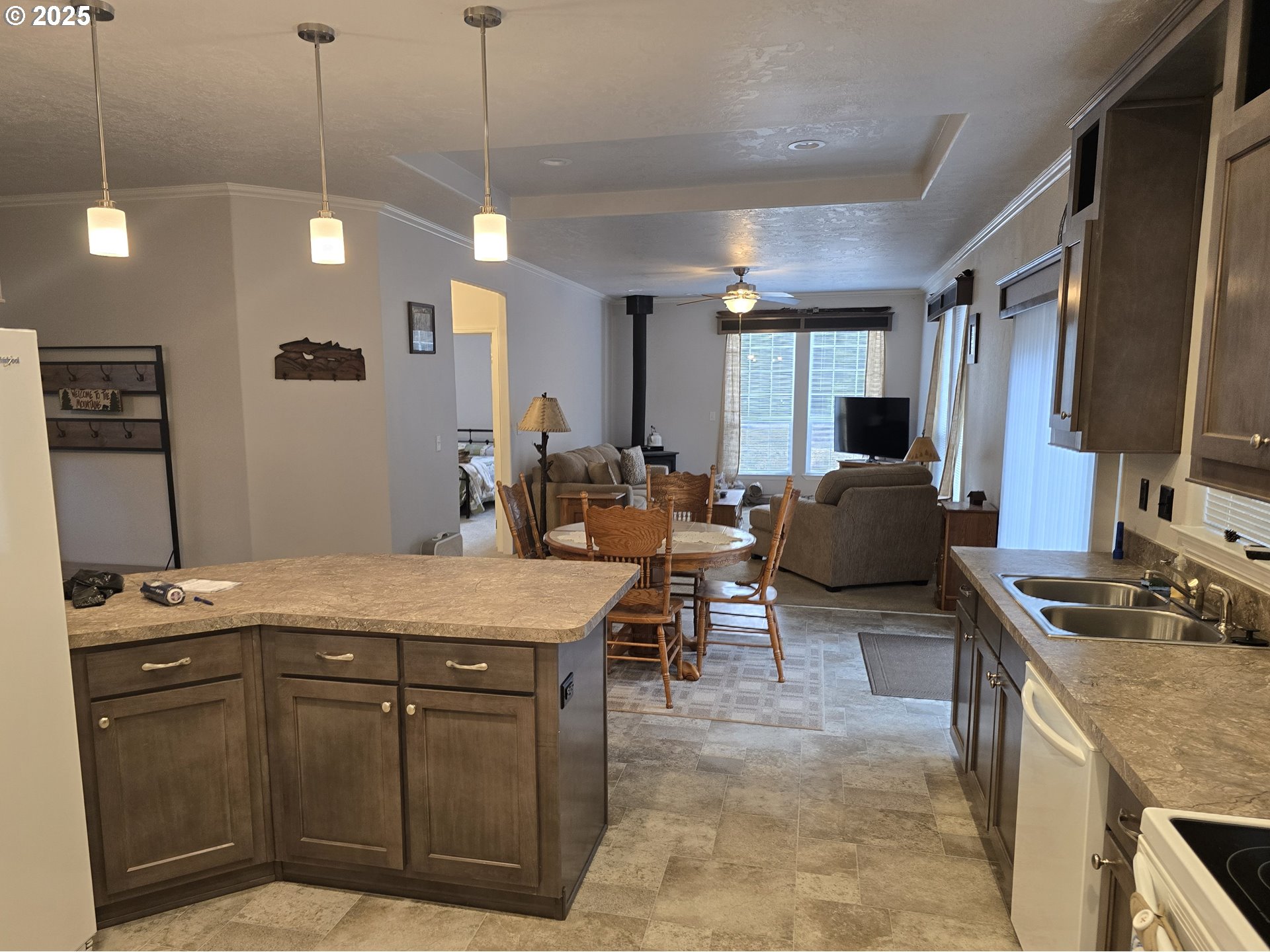 125220 Cappy Court Crescent Lake, OR 97733 - Photo 10 of 34 a kitchen with stainless steel appliances granite countertop wooden cabinets a stove a sink a dining table and chairs with wooden floor