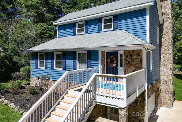 a view of a house with a deck and a yard