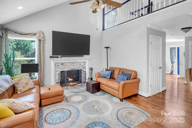 a living room with furniture a flat screen tv and a fireplace